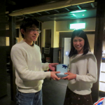 在校生よりM2 山田さん(右)へ修了祝いのプレゼント贈呈
