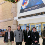 会場入り口にて / 左から金子特別研究員、吉本教授、M2 森田、松田講師